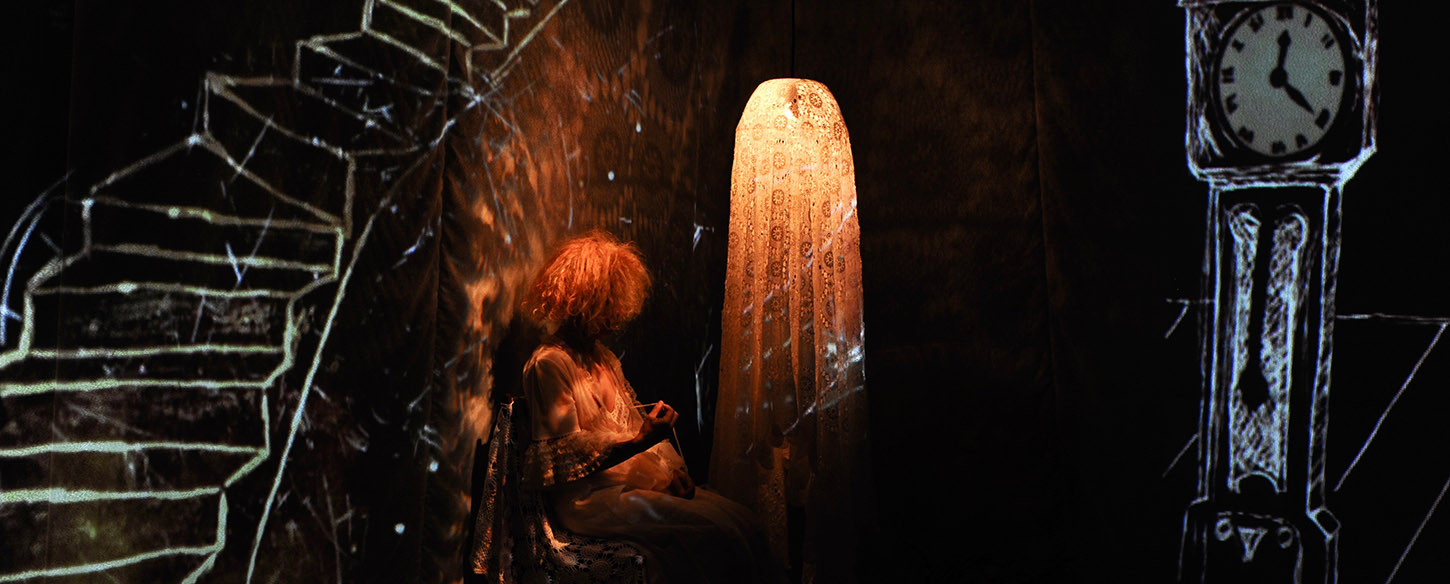 a woman sits in a dark room with hand drawn animations on the wall