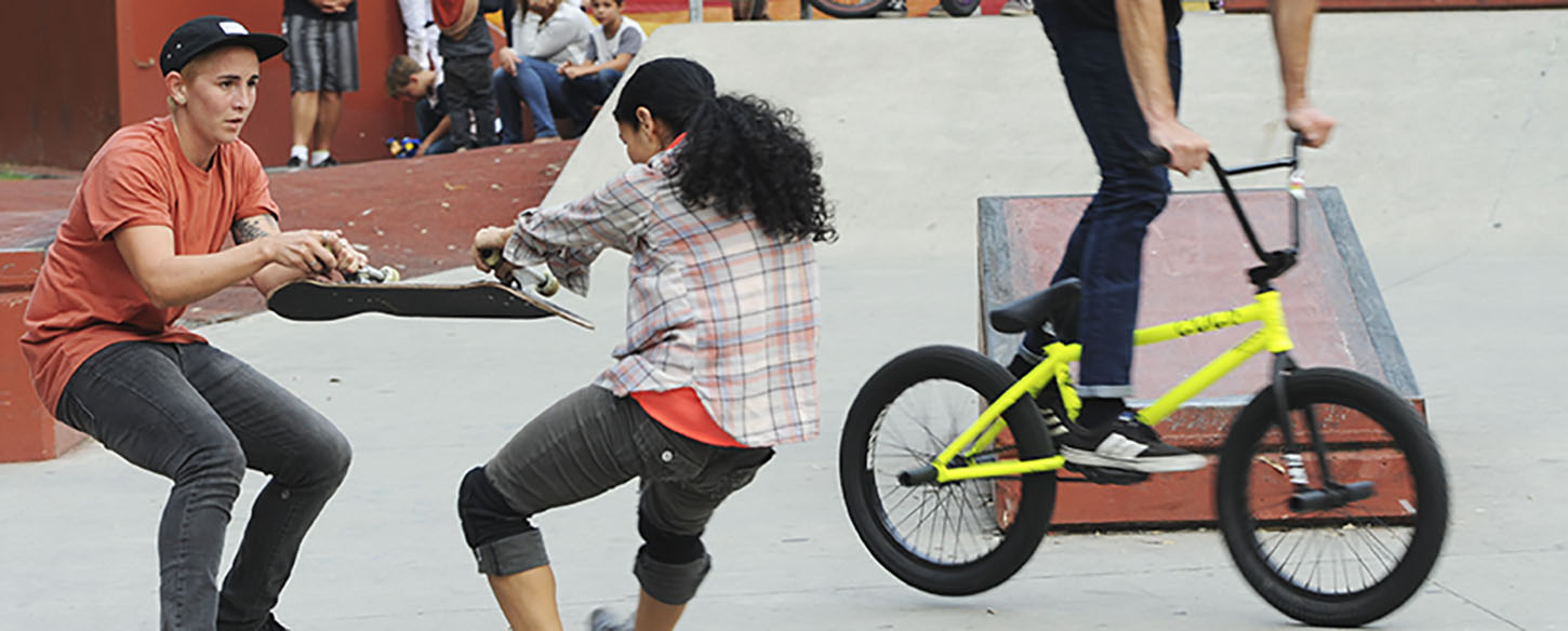 two young people fight over a skateboard