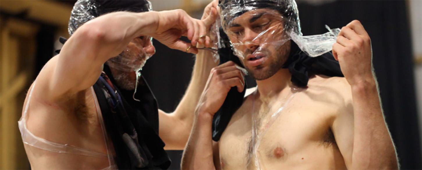 two men wrap their heads in cling wrap